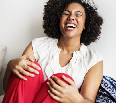 白色墙壁前黑色卷发时尚商务女性