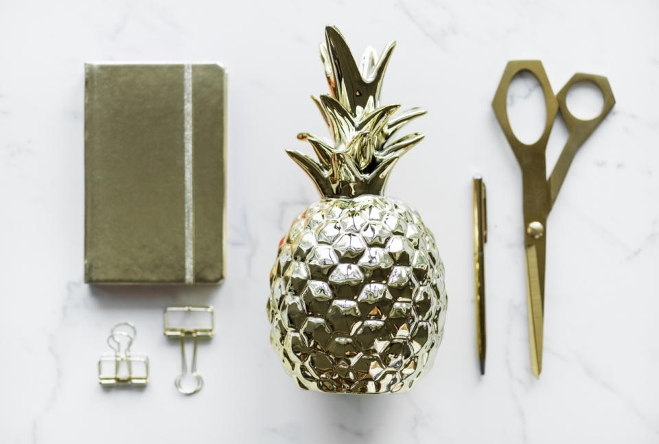 摄影入门教程_白色石质桌面金色金属菠萝装饰