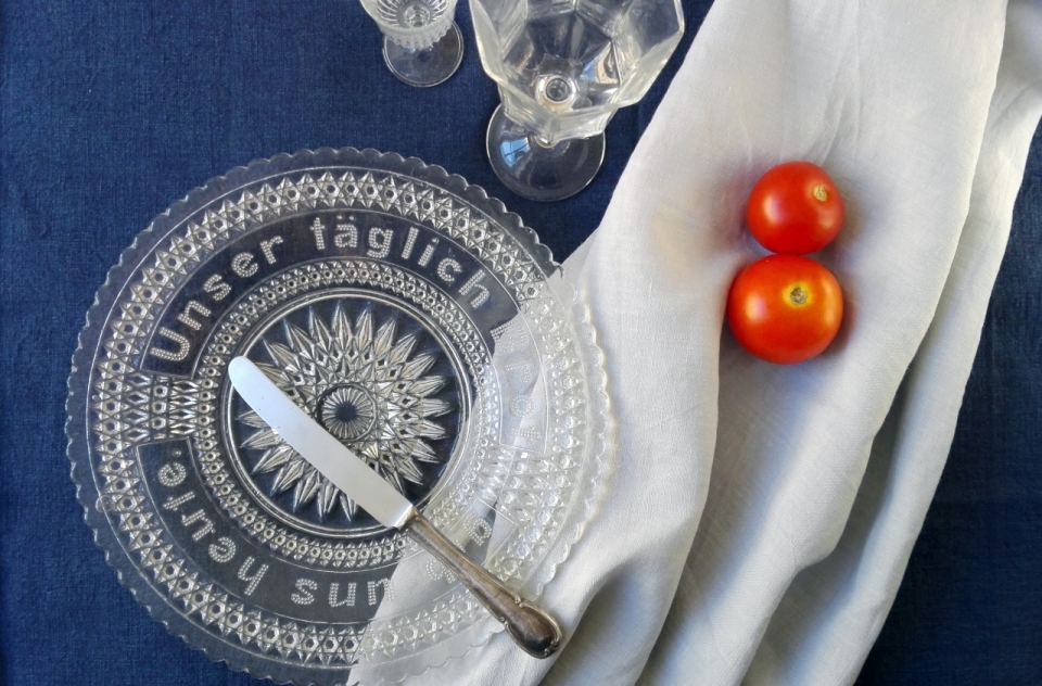 蓝色桌布上玻璃盘子和西红柿静物摄影