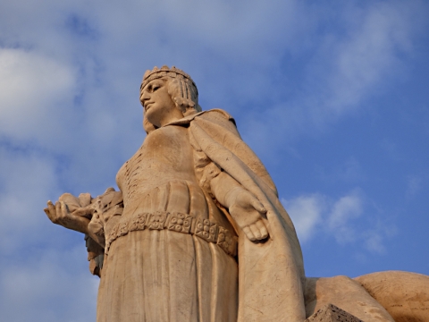 蓝色天空古老艺术女性石质雕像仰拍