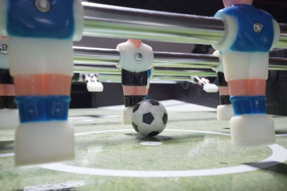 桌式足球的玩具小人和足球的近景特写