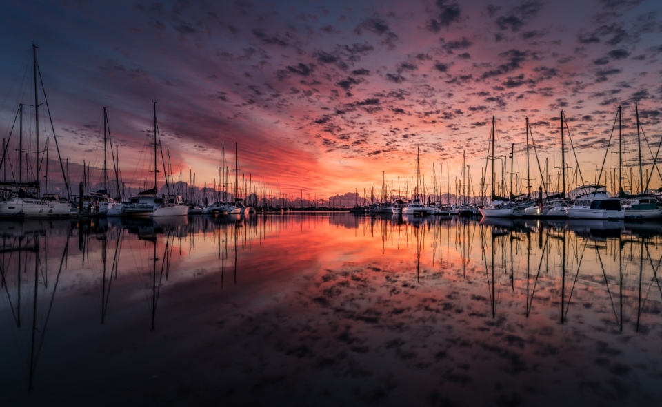 夕阳红日下的湖畔码头镜像摄影