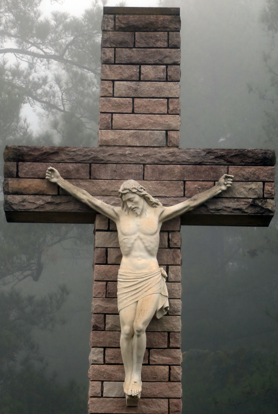 雾气弥漫森林背景红砖十字架上的耶稣雕像
