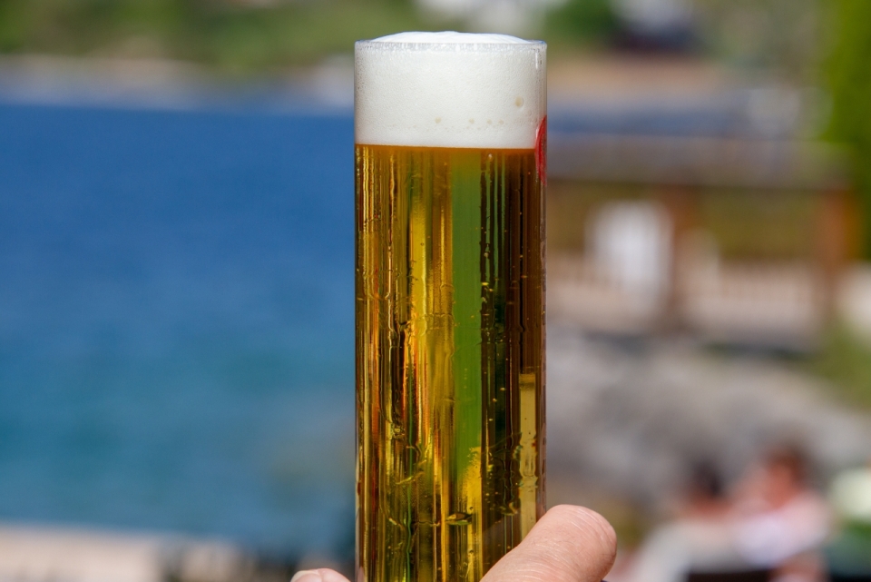 阳光虚化背景前玻璃啤酒杯黄色美味啤酒
