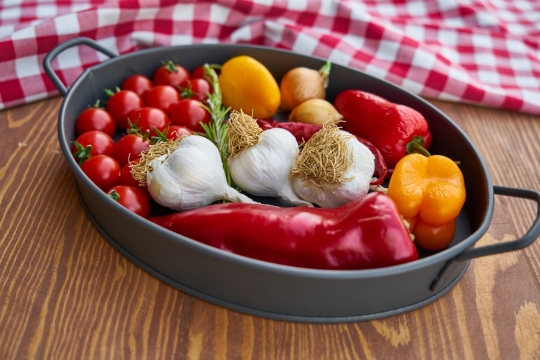 放在平底锅中的辣椒番茄大蒜等食材摄影