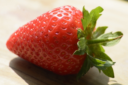 阳光下木制桌面新鲜美味红色草莓