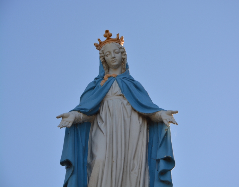 蔚蓝天空下头戴王冠身披蓝色披风的圣母像