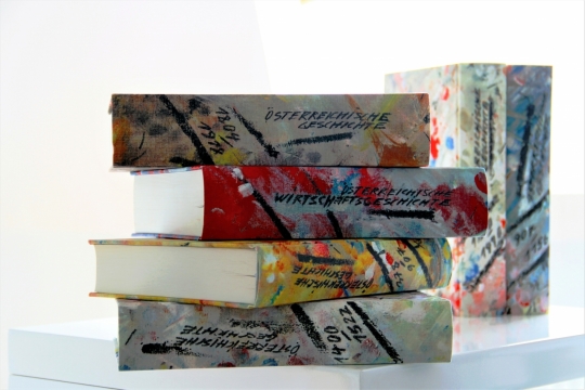 白色桌子上叠在一起的彩色硬壳书本