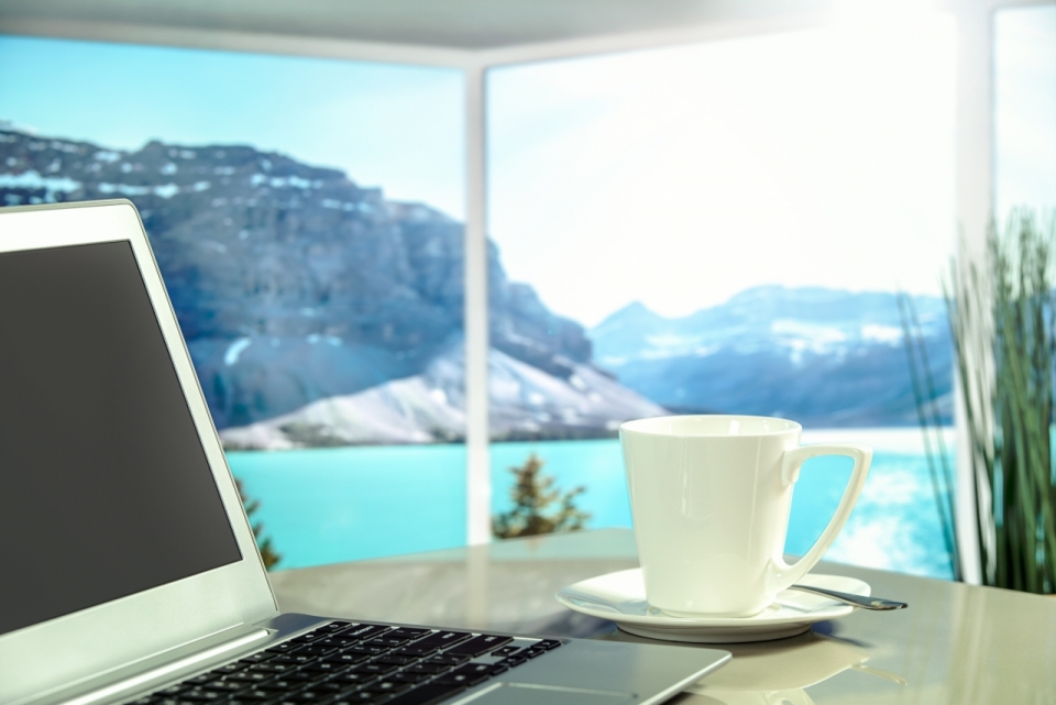 优美海景风光的办公室办公桌上放着咖啡和电脑