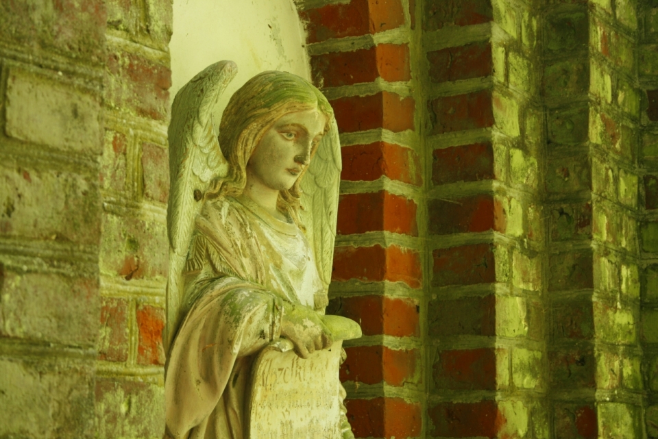 破旧房屋边摆放女性天使人物雕像