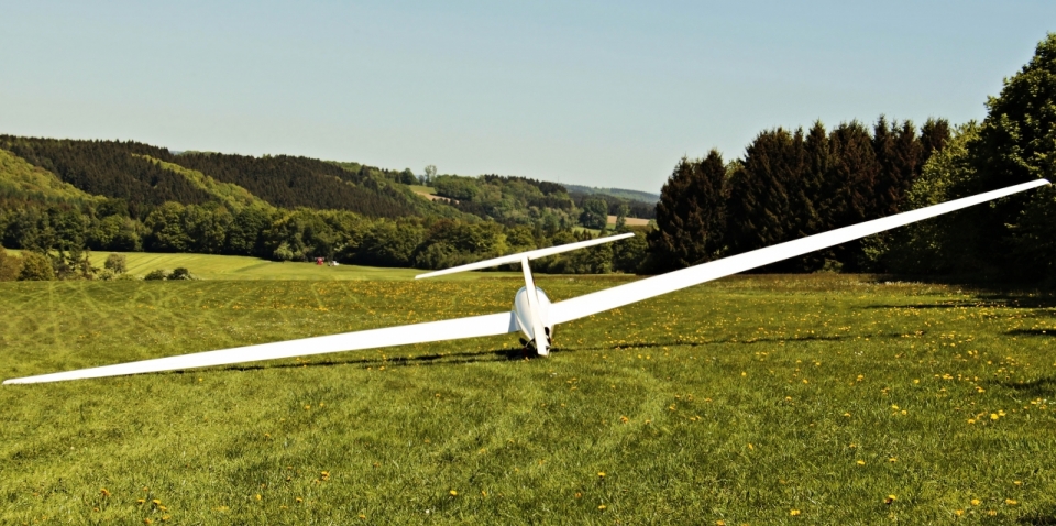 山坡碧绿草地飞行白色飞机模型