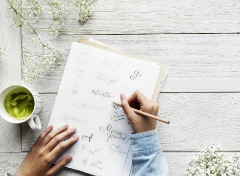 白色木制桌面笔记本上书写文艺艺术字体