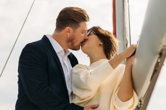 在栏杆旁一对情侣亲吻的浪漫摄影