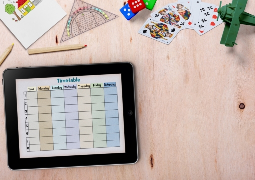 木桌上黑色平板电脑和文具玩具