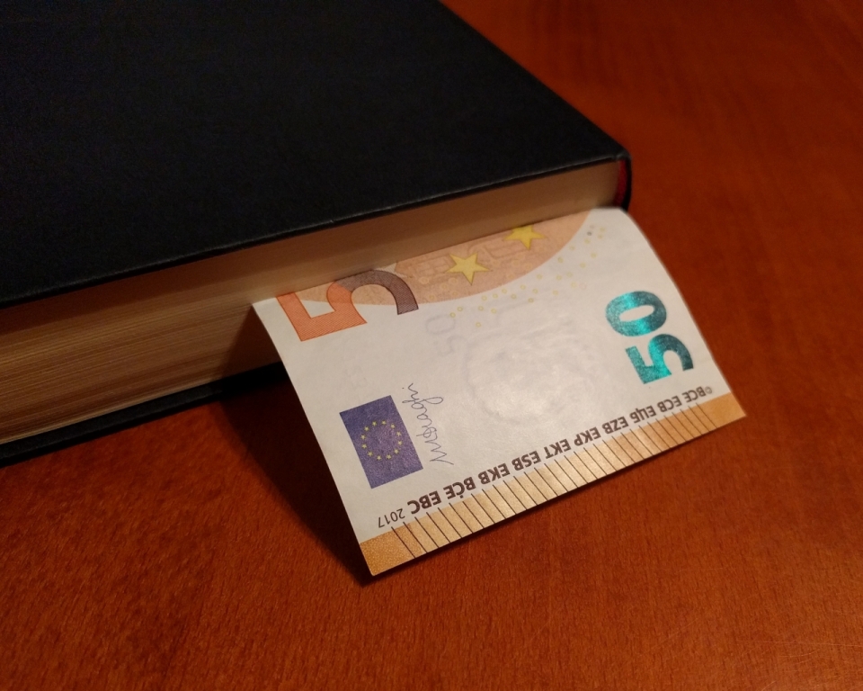木桌上黑皮书本中夹着的50欧元纸币