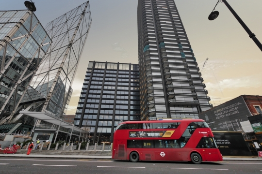 现代城市街道高楼大厦前红色公交车