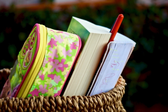 背景虚化竹篮中的背包和书本