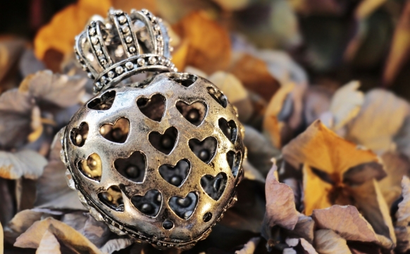 背景虚化枯黄腐烂树叶上爱心镂空金属制品