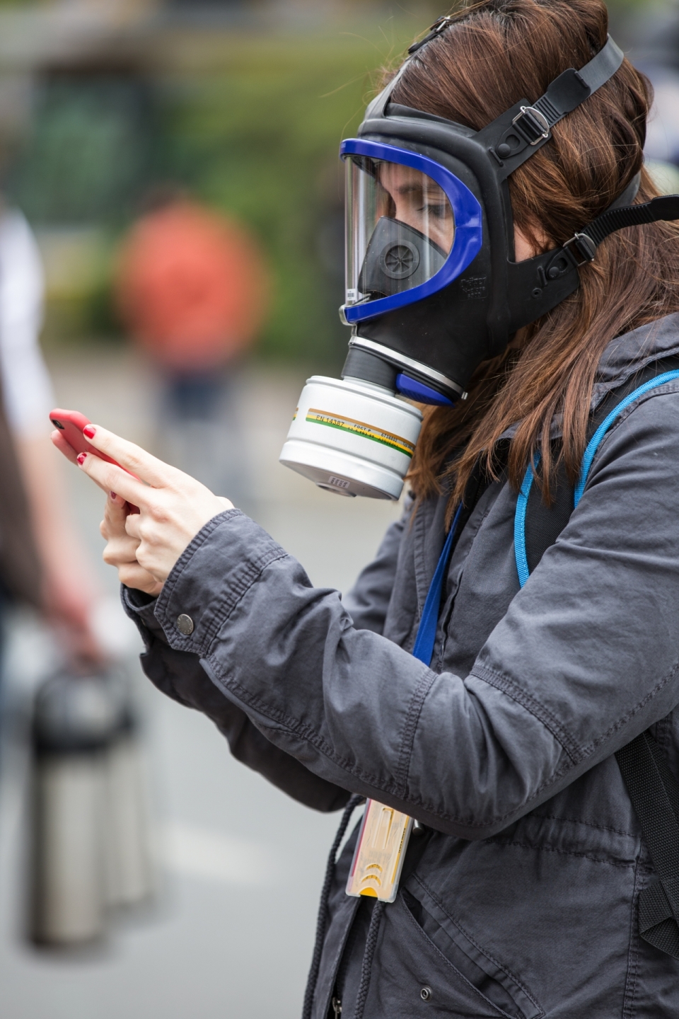 背景虚化大街上戴防毒面具玩手机的女人