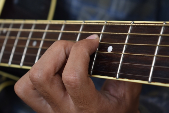 正在弹吉他的人手部和琴弦特写摄影