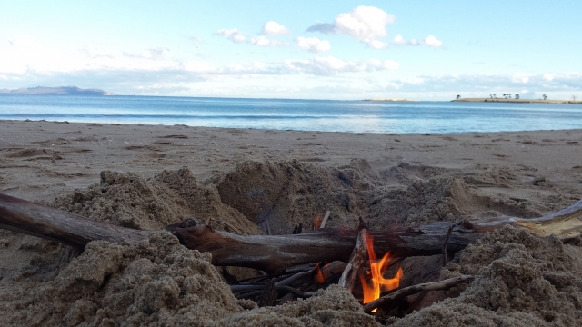 海边沙滩燃烧木桩火焰摇曳外景