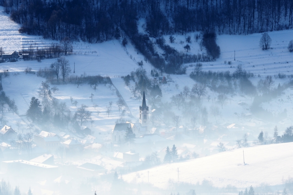 雪山下雾气笼罩的村庄