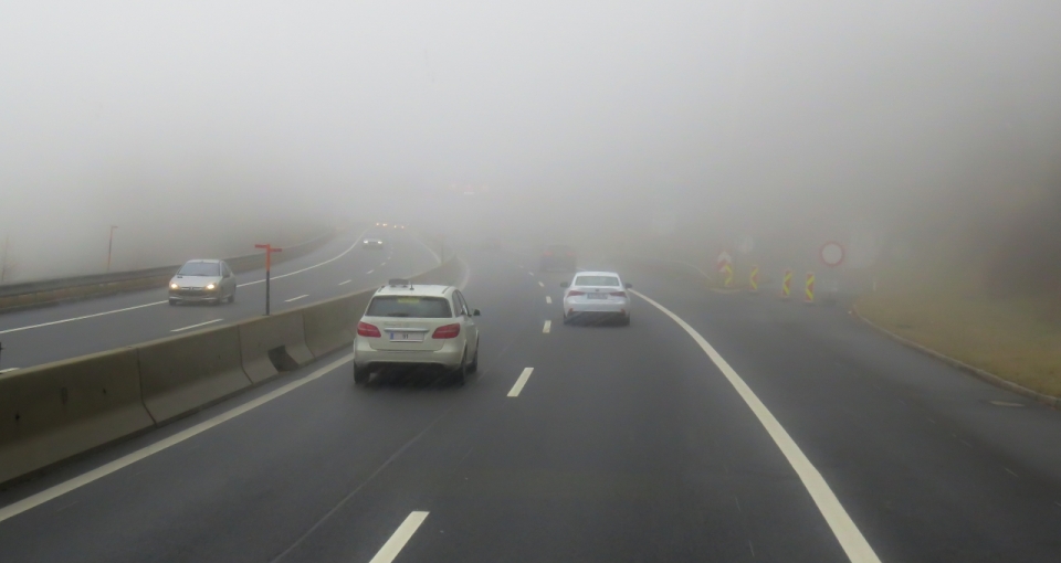 行驶的车辆和满是雾气的道路