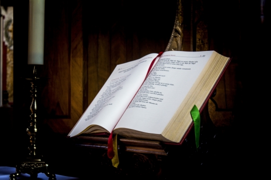 昏暗教堂室内翻开圣经黑色文字书本