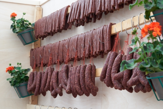 家中墙壁木杆上悬挂精心腌制香肠腊肉美食