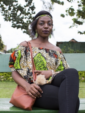 虚化背景城市街道长椅上时尚黑人女性