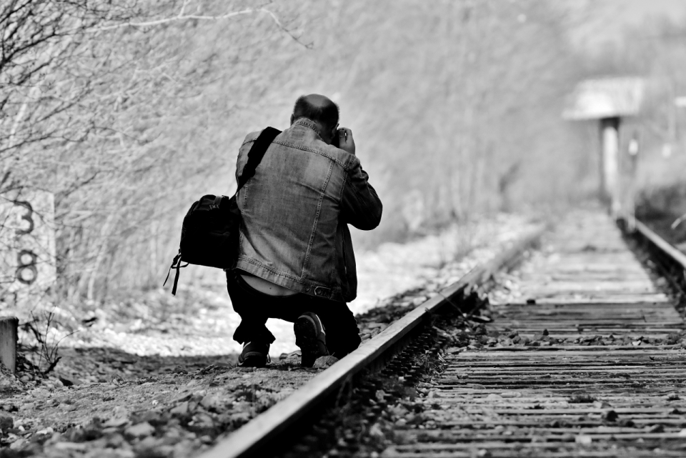 黑白色树林边火车轨道摄影师拍摄背影