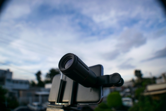 蓝天白云下带着望远镜的手机