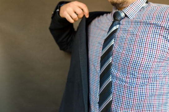 一个打着领带正在穿西装的男人