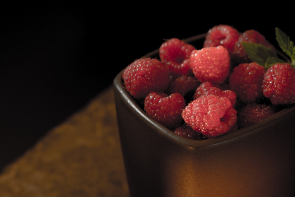 室内木桌金属容器内红色新鲜树莓果实