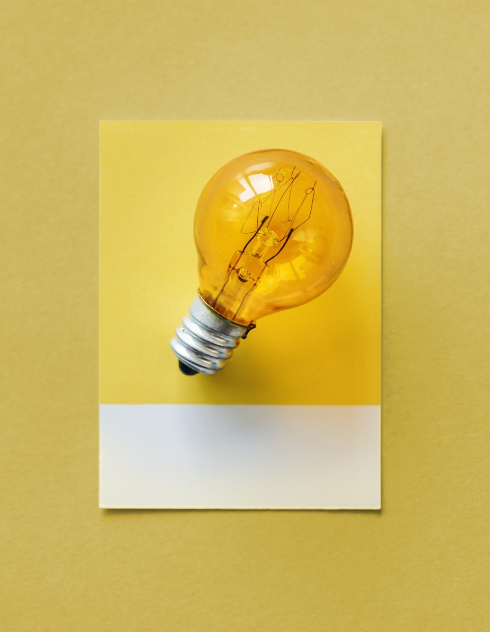 黄色背景纸质卡片透明橙色玻璃灯泡