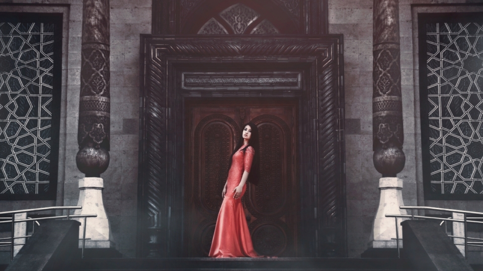红色长裙美女站在古建筑门前写真