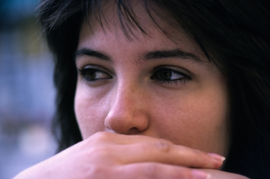 人物摄影_虚化背景捂嘴黑发女性面部特写