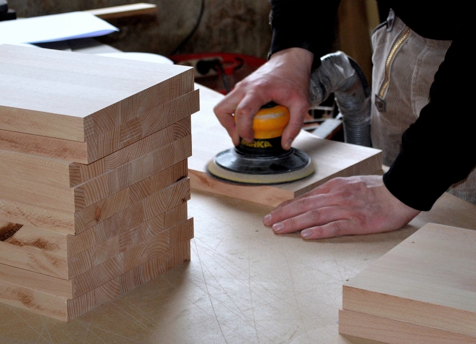 工厂房屋木匠打磨木板工作特写