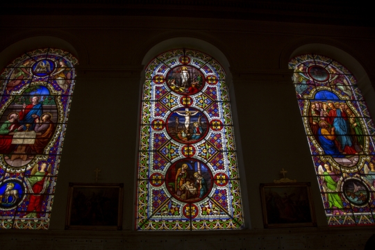 幽暗教堂中画着宗教故事的美丽玻璃窗