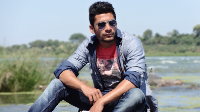 人物摄影_坐在池塘边戴墨镜的男性