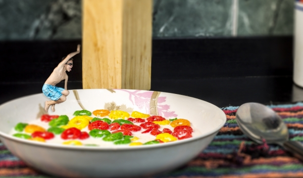 穿沙滩裤的男子跳入泡有彩色糖果的牛奶