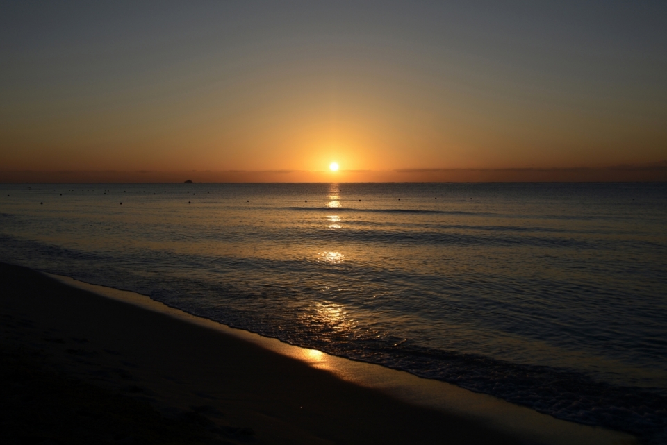 海边沙滩夕阳落入地平线唯美风光摄影