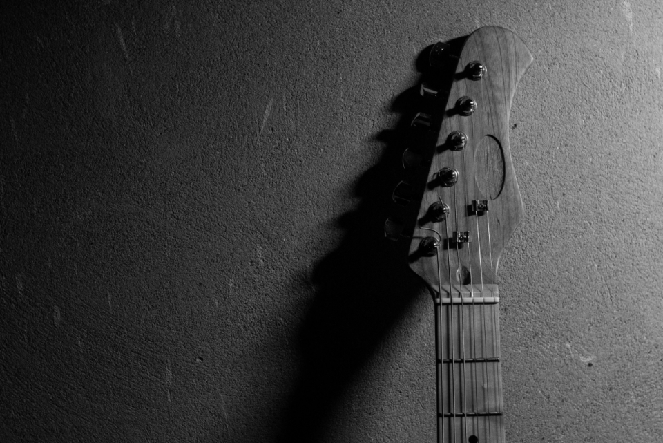吉他柄靠在水泥墙上黑白画面