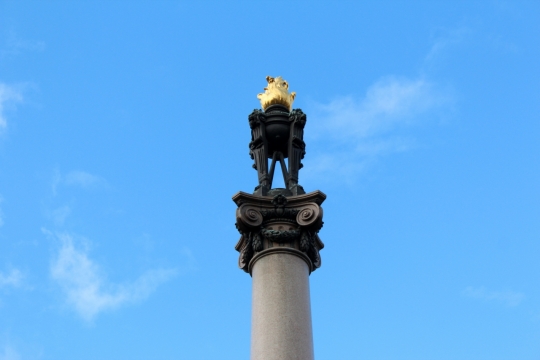 仰视在蓝天白云中屹立的精美艺术雕塑柱子