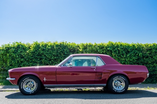 柏油马路停放红色老式肌肉车外观