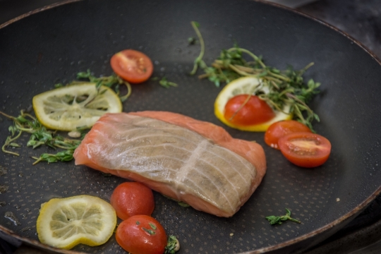 锅中煎制三文鱼香料调味美食