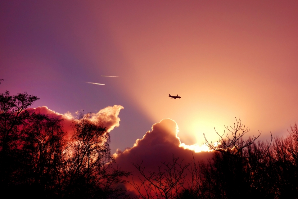 傍晚阳光余晖挥洒的天空中一架飞机正在飞行