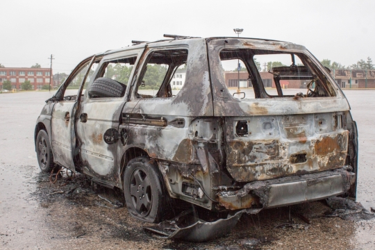 雨后城市街道废弃污损白色面包车
