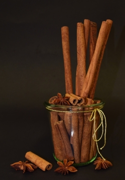 黑色背景前玻璃罐中的桂皮和八角香料