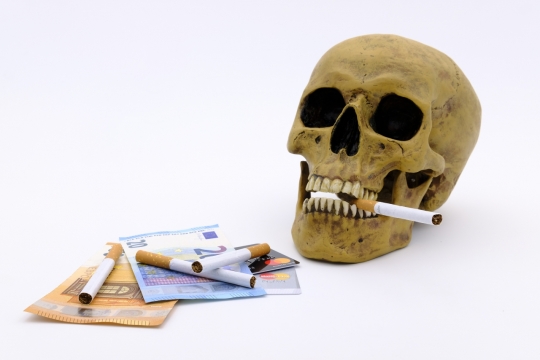 白色背景黄色骷髅模型含香烟公益广告